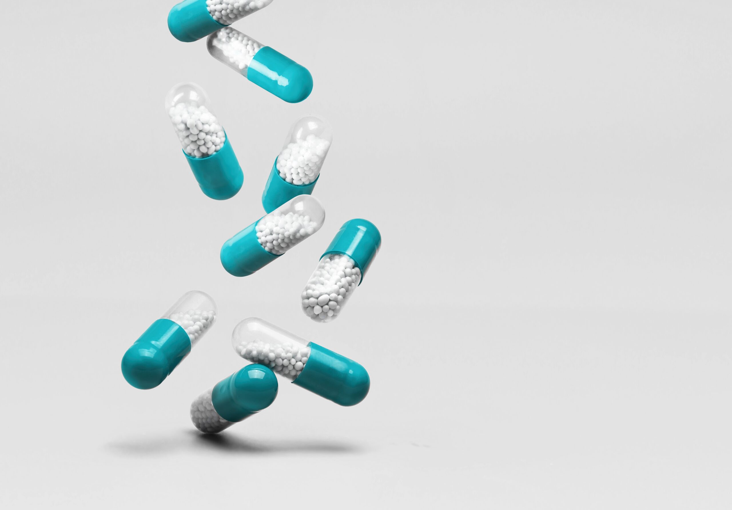 Falling,Blue,White,Medicine,Pills,Capsules,On,White,Background.,Copy